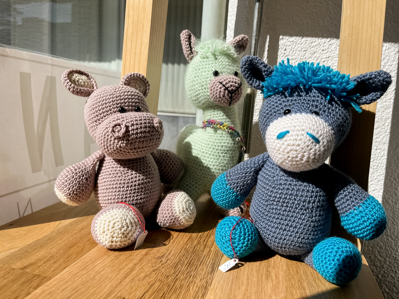 Mehrere kleine Tiere aus bunten Wollknäueln handgefertigt